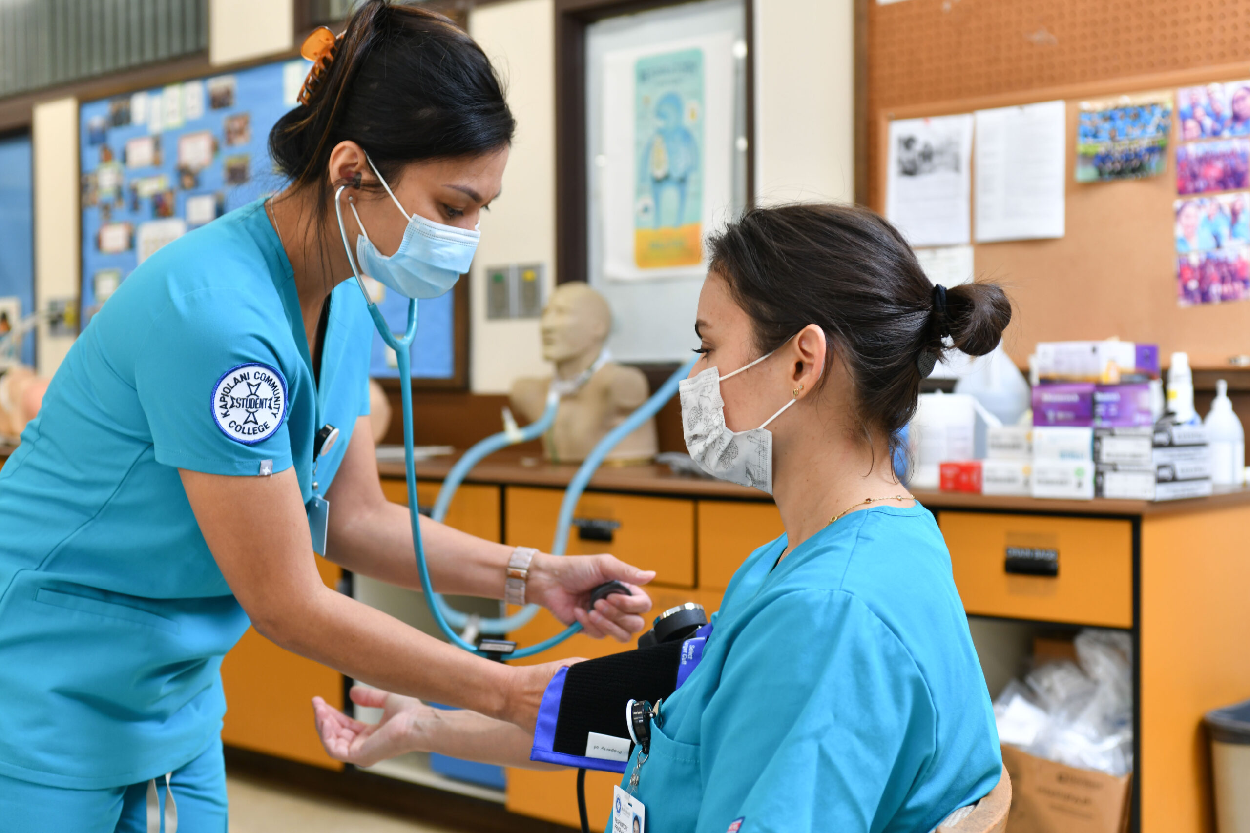 Female nursing student practicing taking blood pressure readings.